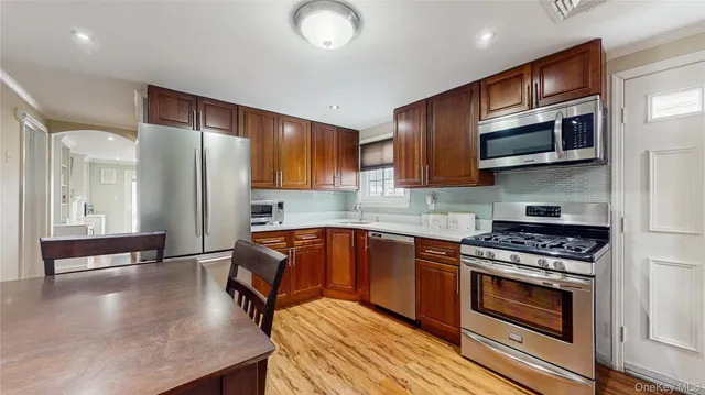 a kitchen with stainless steel appliances granite countertop a stove a refrigerator and a wooden cabinets