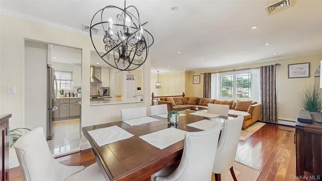 a living room with furniture a large window and stainless steel appliances