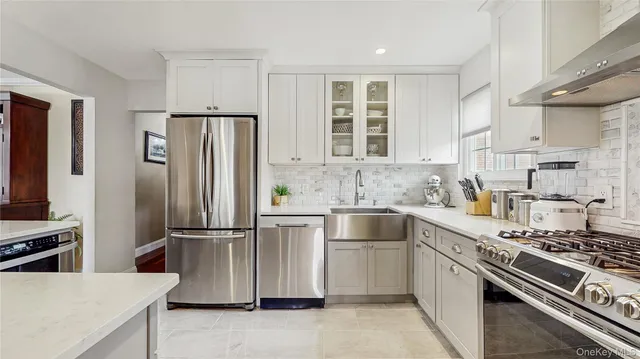 a kitchen with granite countertop a refrigerator stove and sink