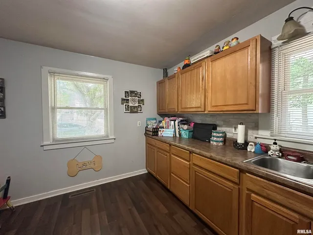a kitchen with granite countertop wooden cabinets a sink and dishwasher