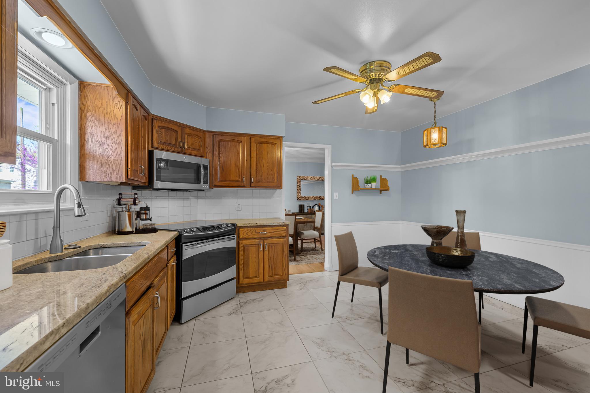 2502 Raven Road Wilmington, DE 19810 - Photo 7 of 57 a kitchen with stainless steel appliances granite countertop a sink a stove a refrigerator a microwave oven with a dining table and chairs