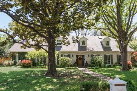 a view of a house with a tree in a yard