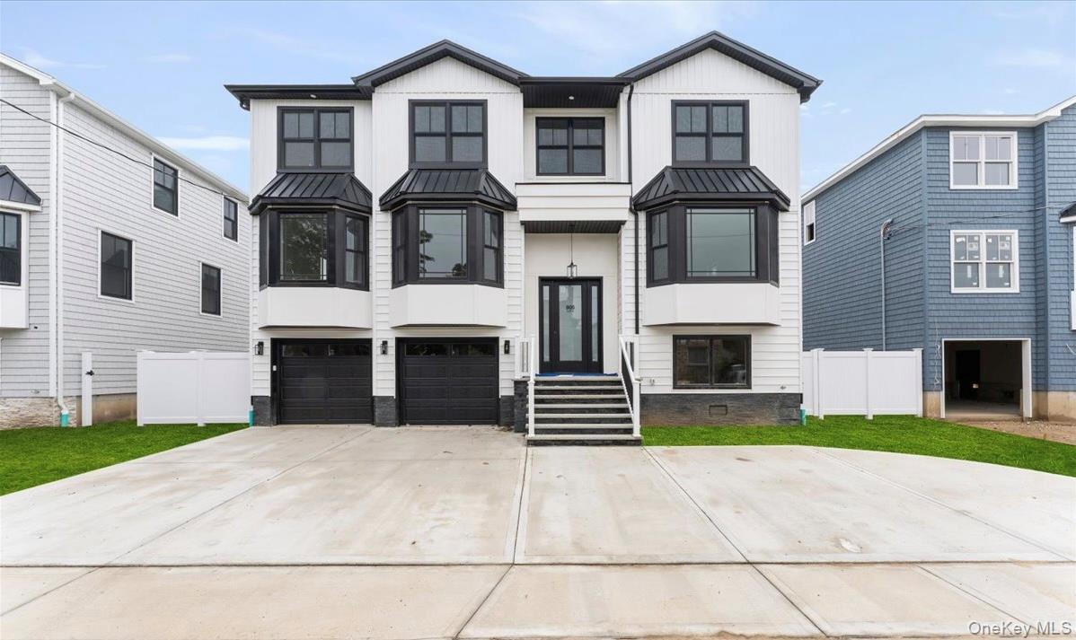 View of front of home with a metal roof, a standing seam roof, concrete driveway, and an attached garage