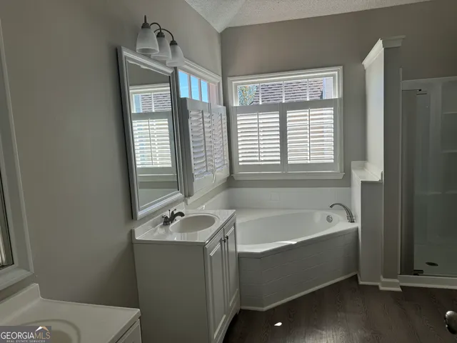 a bathroom with a tub a sink and a window