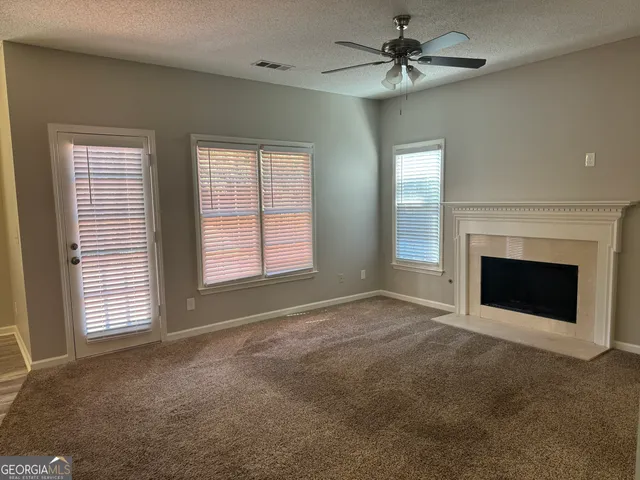 an empty room with windows and fireplace
