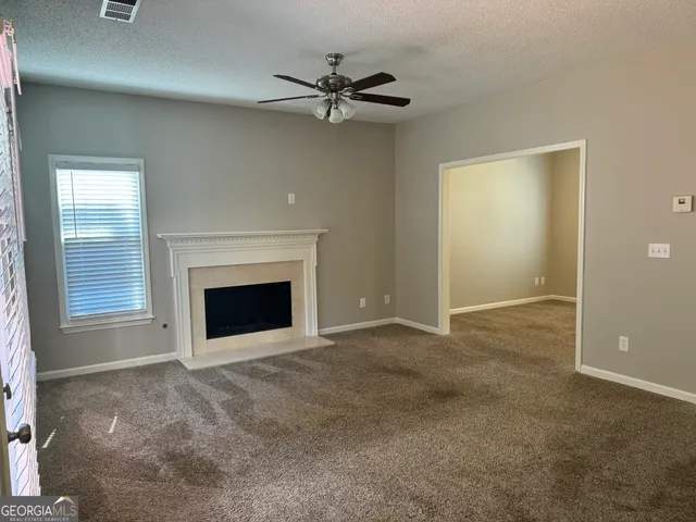 a view of a livingroom with a fireplace and a ceiling fan