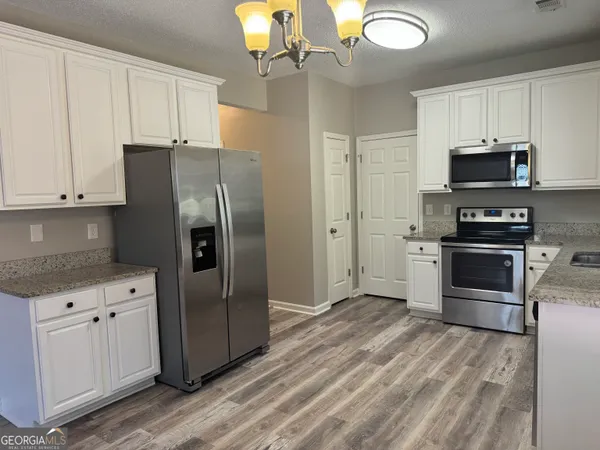 a kitchen with stainless steel appliances a stove a refrigerator and a sink