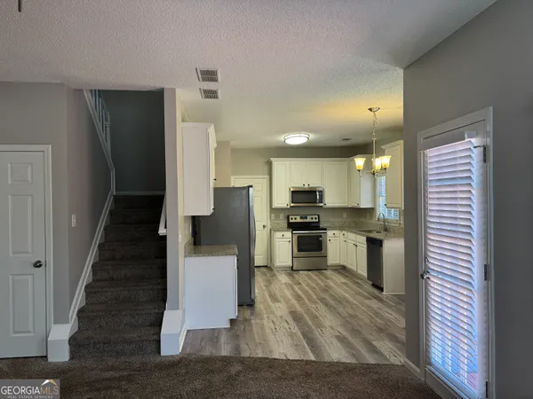 a kitchen with white cabinets and stainless steel appliances
