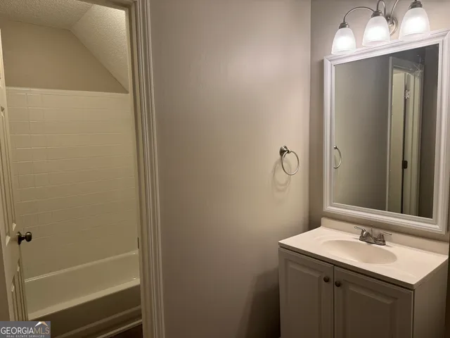 a bathroom with a sink and mirror with toilet