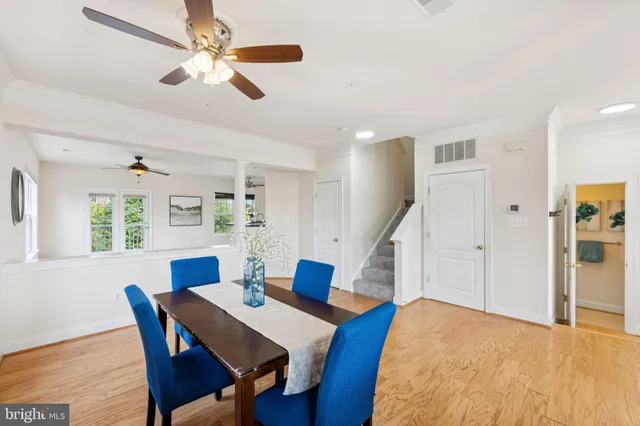 a dining room with furniture a chandelier and wooden floor