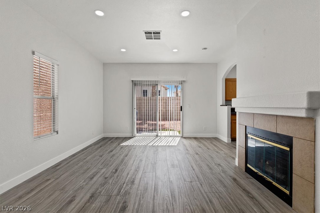 1412 Beaver Spring Street Las Vegas, NV 89128 - Photo 4 of 20 A well-lit living area showcases a sleek fireplace and convenient outdoor access.