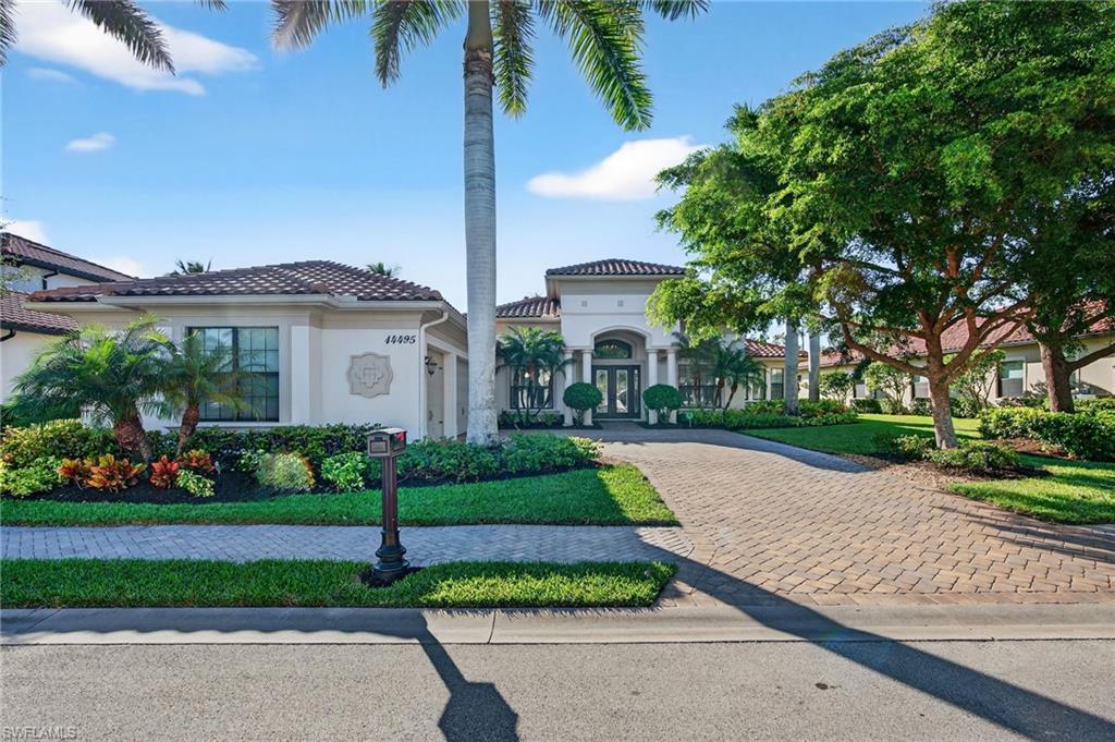 a front view of a house with a yard and potted plants