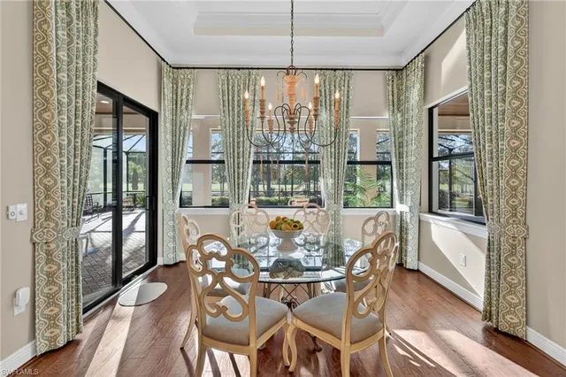 a view of a dining room with furniture large windows and wooden floor