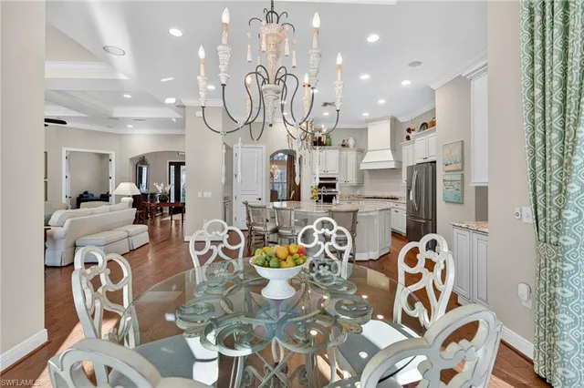 a kitchen with stainless steel appliances granite countertop a table and chairs in it