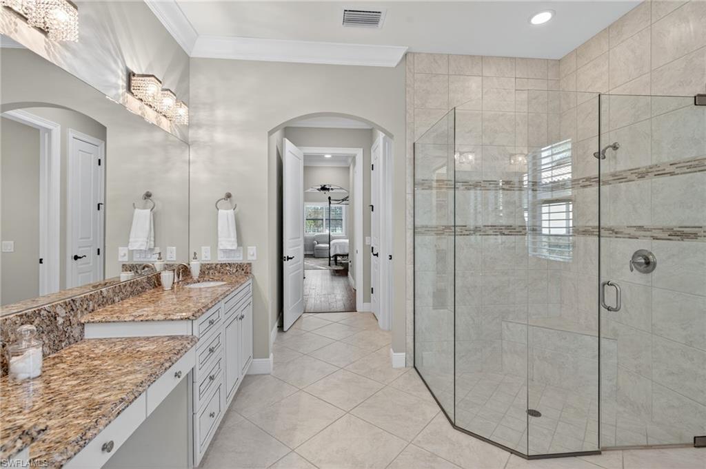 14495 Marsala Way Naples, FL 34109 - Photo 19 of 45 a spacious bathroom with a granite countertop sink mirror and shower