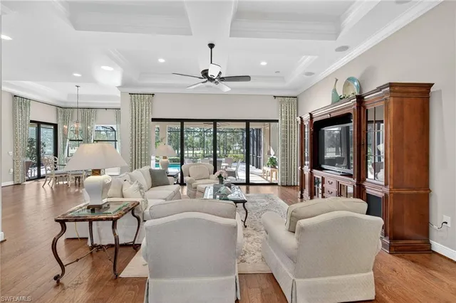 a living room with furniture ceiling fan and a flat screen tv
