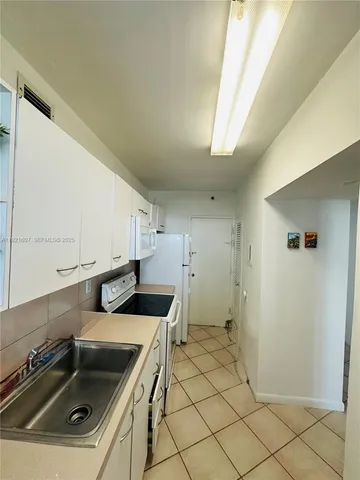 a bedroom with 2 bed and a lamp on table