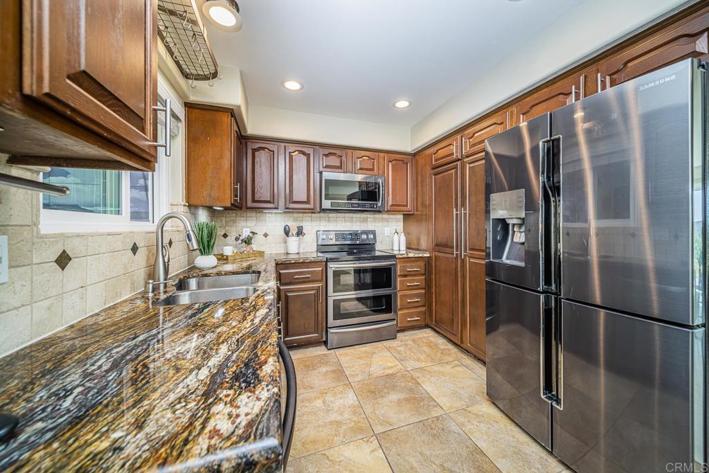 3801 Orange Way Oceanside, CA 92057 - Photo 22 of 52 a kitchen with stainless steel appliances granite countertop a refrigerator oven a sink and dishwasher