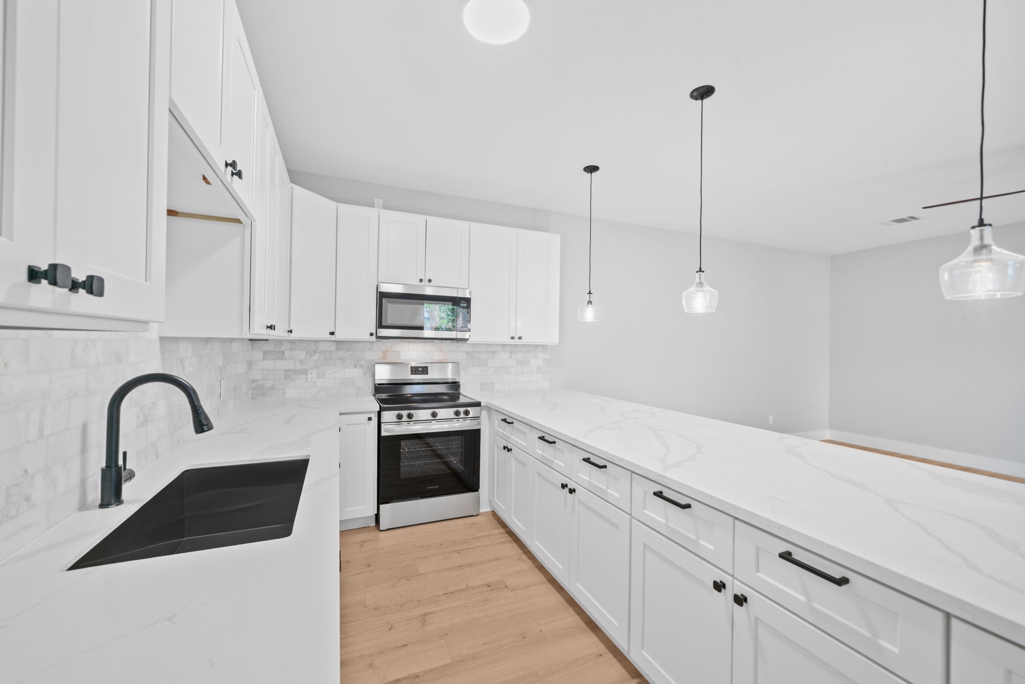 9918 Fillmore Street Houston, TX 77029 - Photo 27 of 35 a kitchen with stainless steel appliances granite countertop a sink a stove a refrigerator and white cabinets with wooden floor