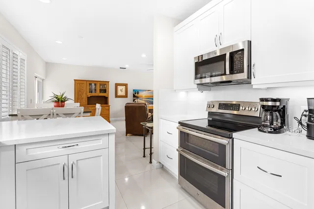 a kitchen with white cabinets and stainless steel appliances