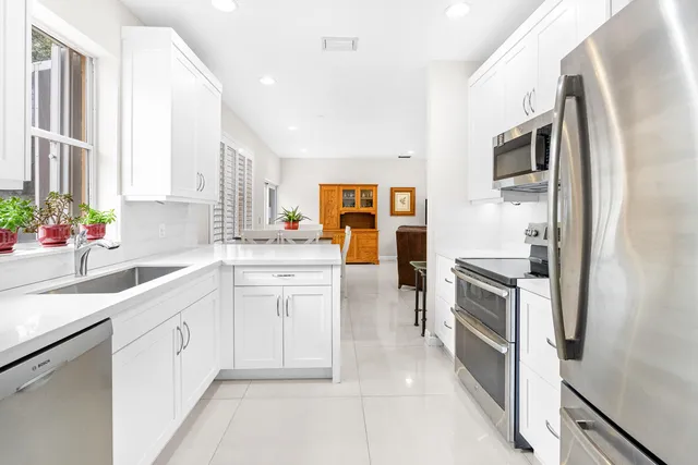 a kitchen with white cabinets and stainless steel appliances