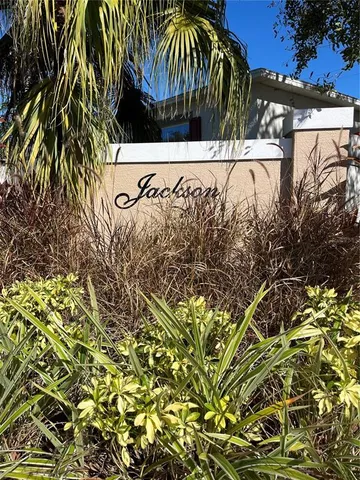 a view of swimming pool with a yard and tree in front of it