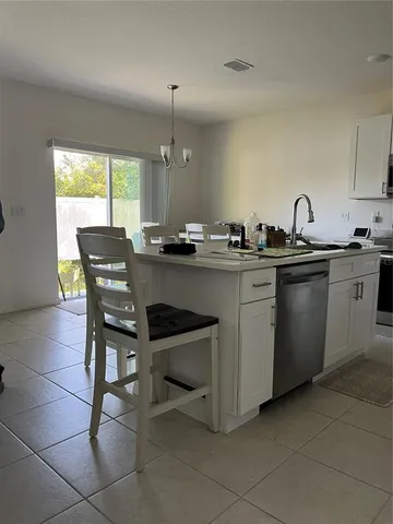 a kitchen with granite countertop a sink a stove a table and chairs in it