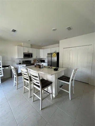 a kitchen with a table chairs sink and microwave