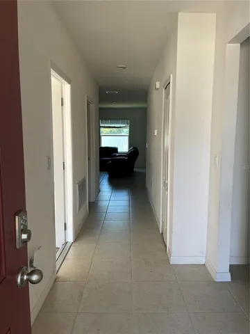 a view of a hallway with a livingroom and a kitchen space