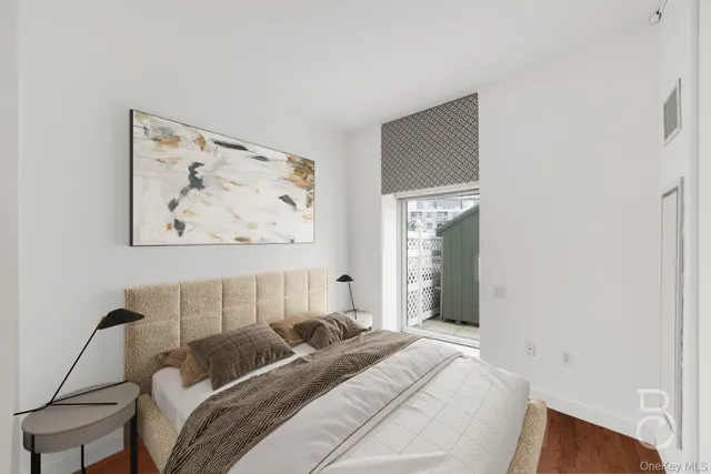 a bedroom with a bed and a painting on the wall