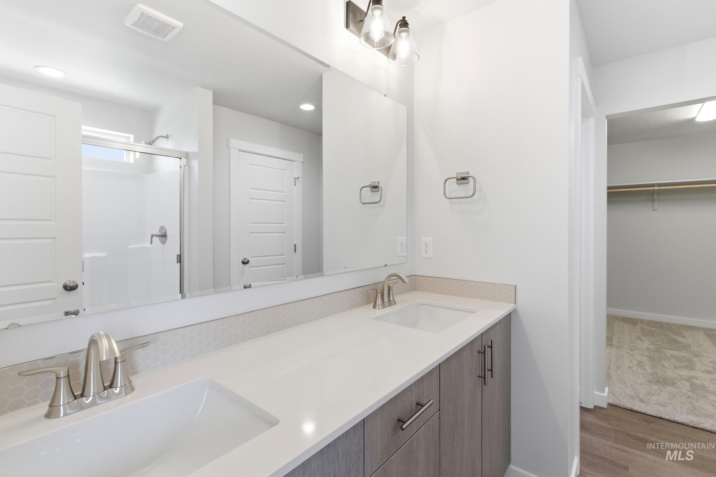 12829 Decatur Street Nampa, ID 83651 - Photo 31 of 33 Double vanity with undermount sinks, light-toned countertops, and brushed nickel fixtures