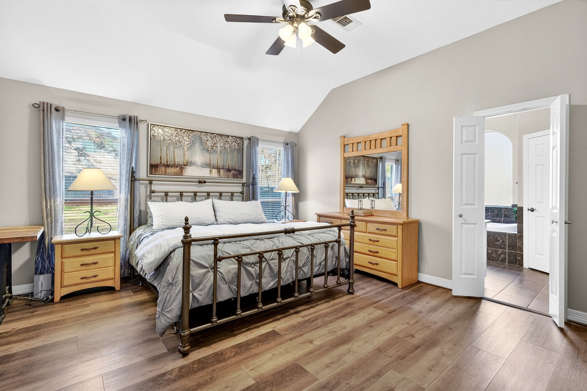 23620 Spring Branch Trail Montgomery, TX 77316 - Photo 11 of 27 Step into the large primary suite with vaulted ceilings, broad windows, and double doors leading to the ensuite bath.