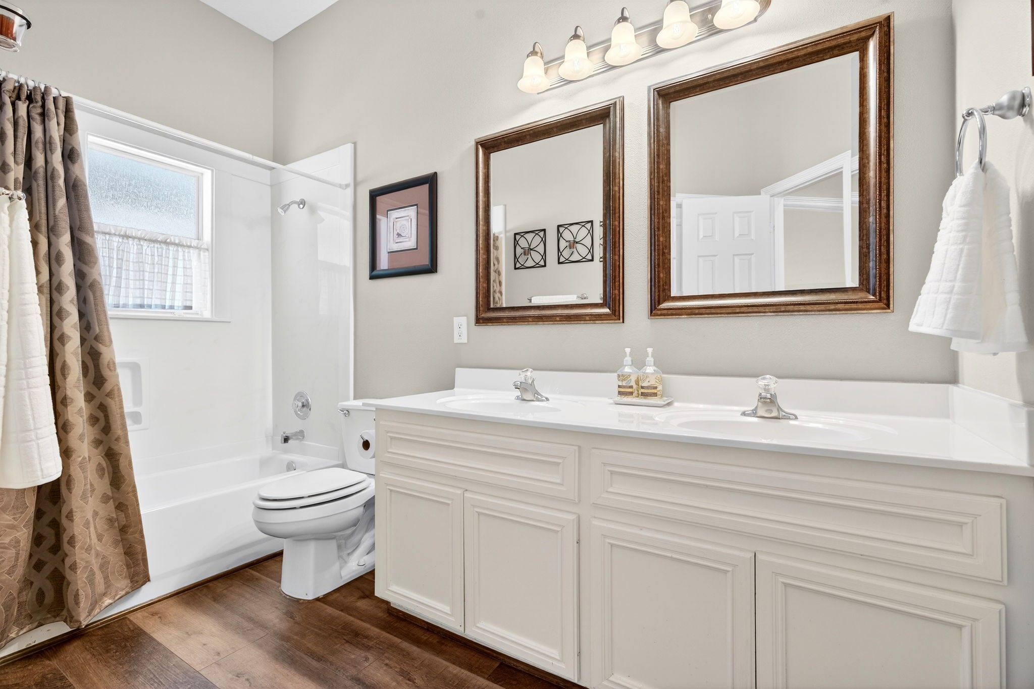 23620 Spring Branch Trail Montgomery, TX 77316 - Photo 17 of 27 The spacious hall bath serves guests with dual sinks, upgraded mirrors and lighting, and a tub/shower combo.