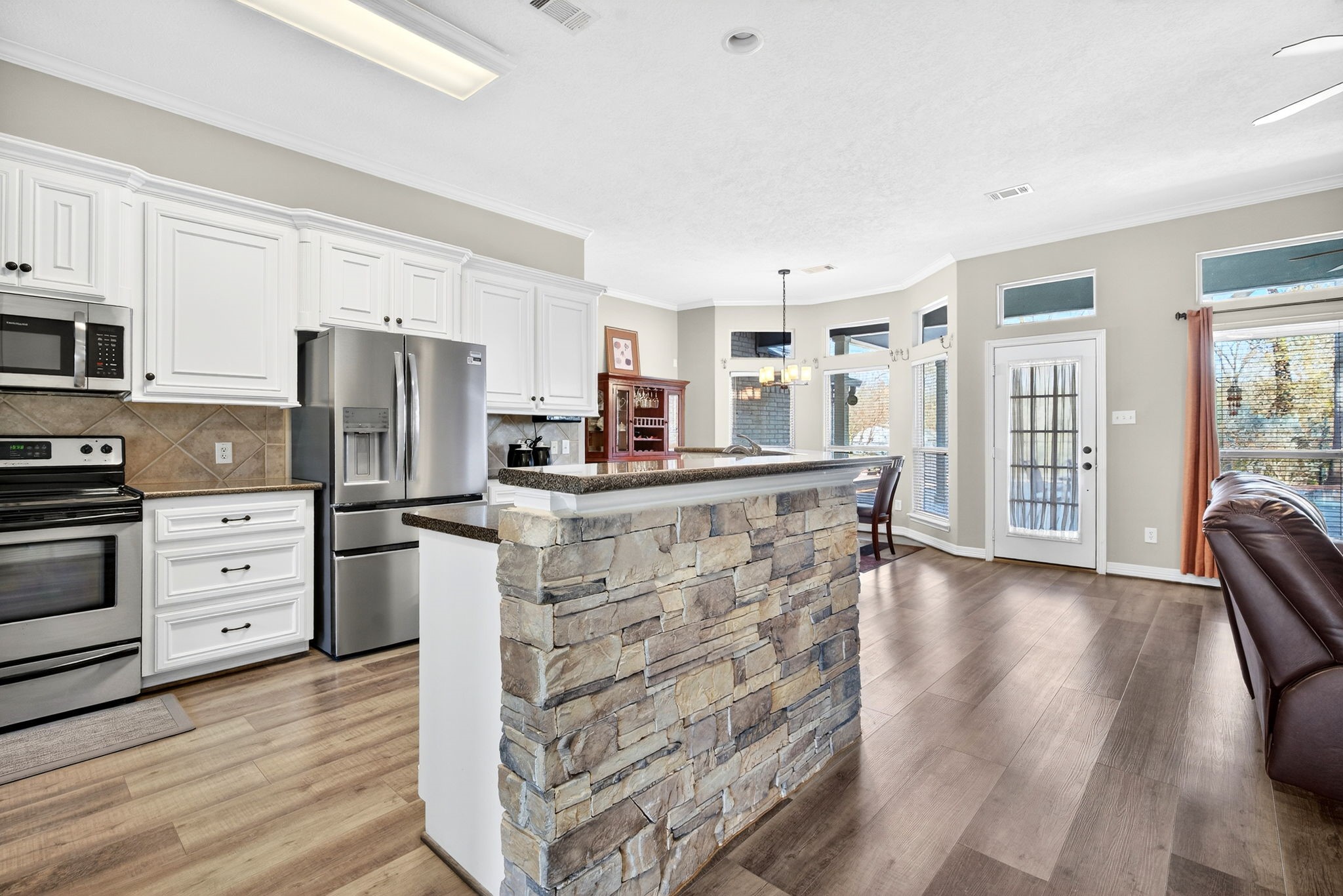 23620 Spring Branch Trail Montgomery, TX 77316 - Photo 7 of 27 The stone-accented island opens to the living room to keep cooks connected to the conversation.