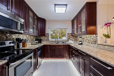 a kitchen with stainless steel appliances granite countertop a sink stove and cabinets