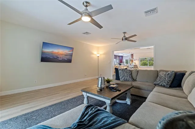 a living room with furniture a chandelier and a window