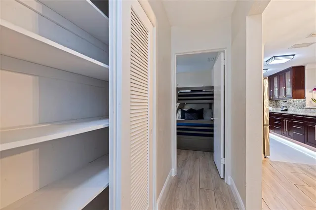 a view of a hallway and wooden floor a living room