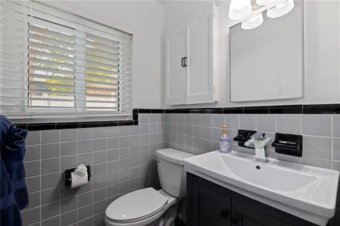 a bathroom with a sink a toilet and a mirror