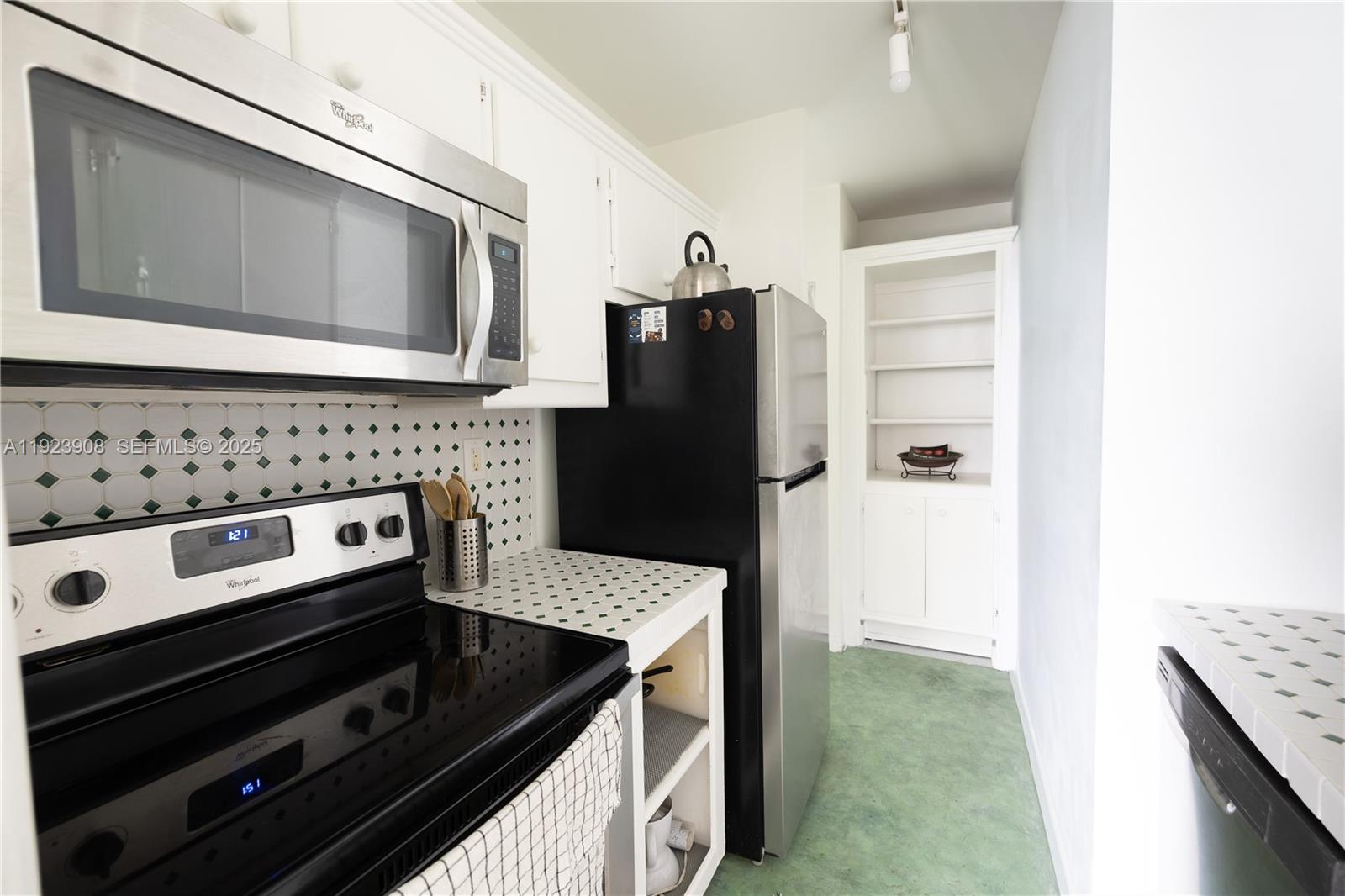 100 Lincoln Road, Unit 1515 Miami Beach, FL 33139 - Photo 8 of 23 a kitchen with granite countertop a refrigerator stove and microwave