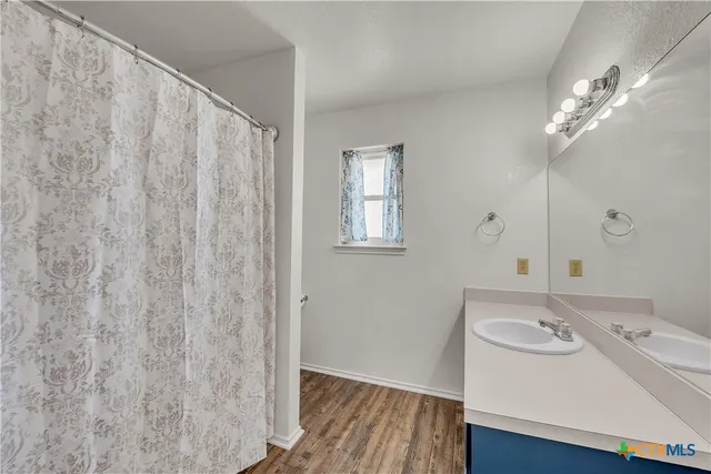 a view of a room with a window and wooden floor