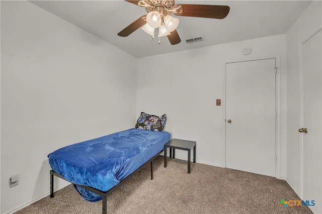 a view of an empty room with a window and a bookshelf