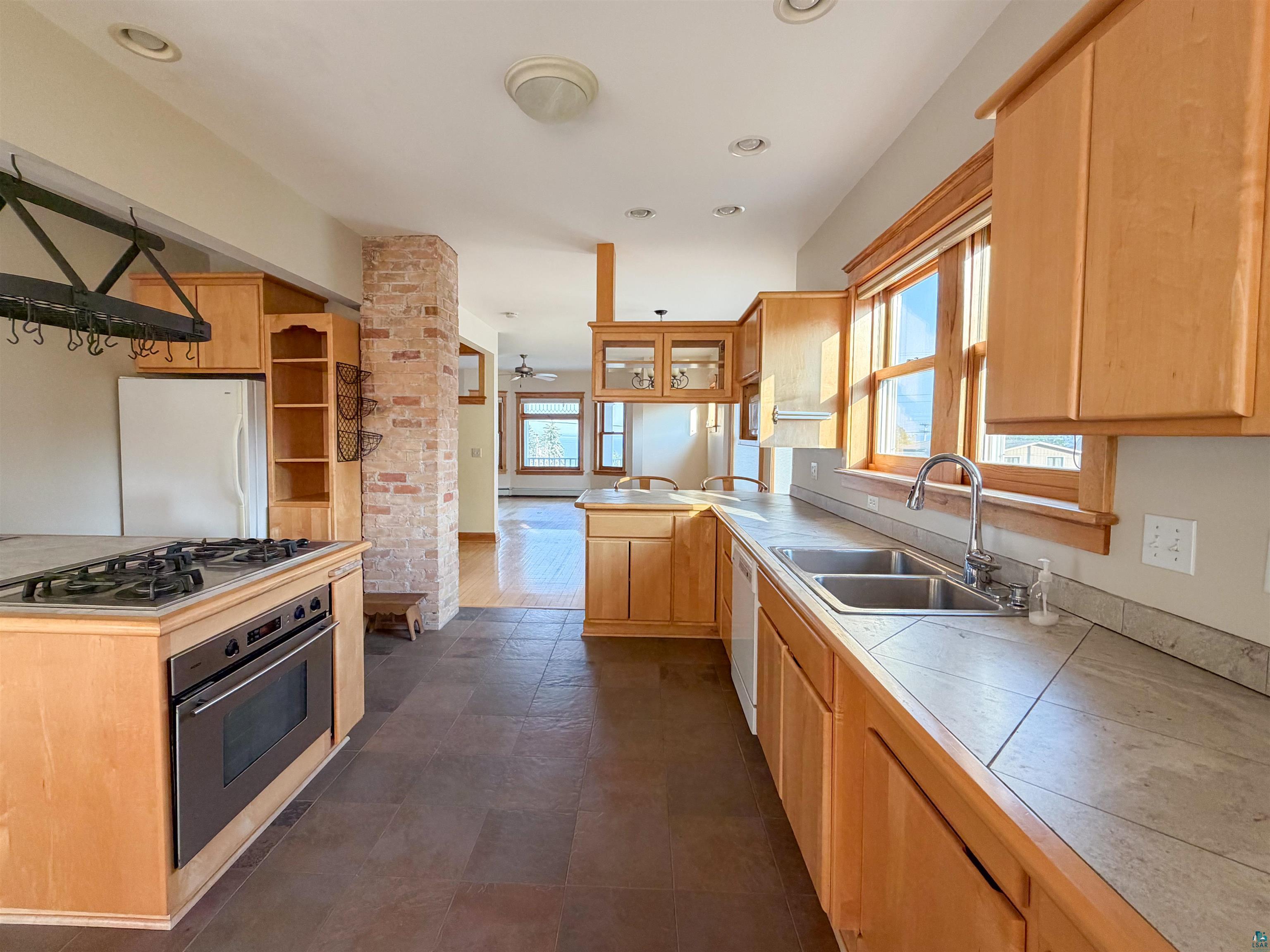 13 West 8th Street Duluth, MN 55806 - Photo 9 of 57 Kitchen featuring light wood cabinetry, dual basin sink, and integrated oven with stovetop