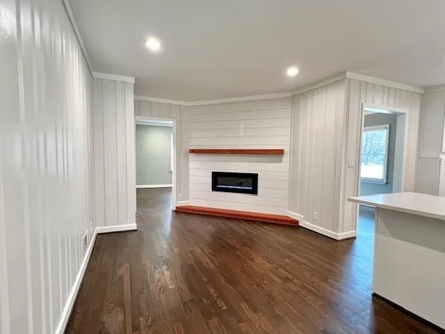 an empty room with wooden floor and fireplace