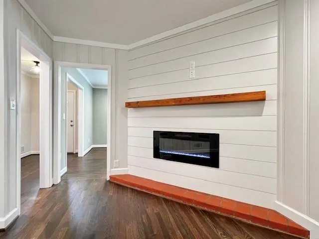 a living room with wooden floor and a fireplace
