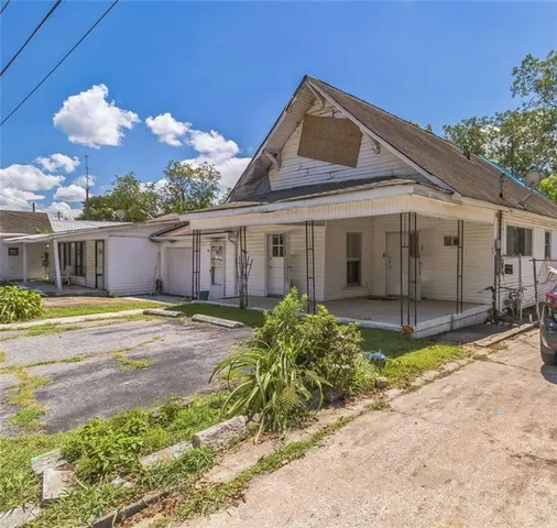 a front view of a house with a yard and potted plants