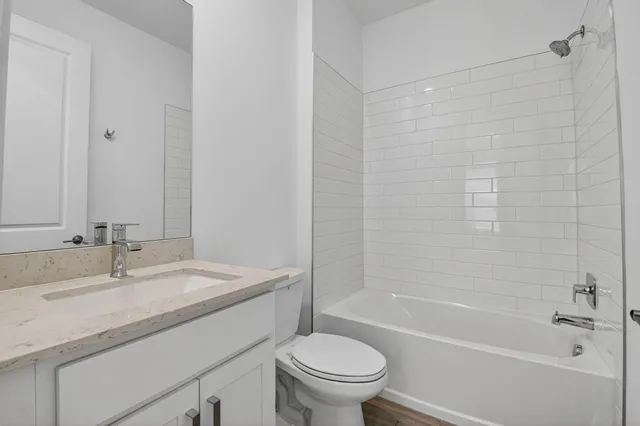 a bathroom with a granite countertop sink a toilet and shower