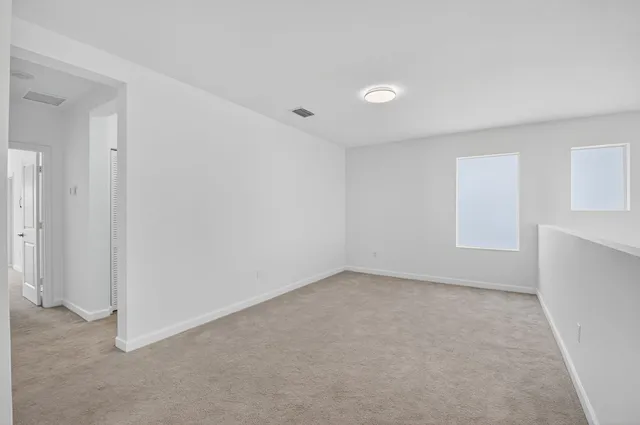 an empty room with a empty space and windows