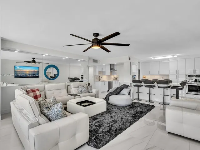 a living room with furniture a rug and ceiling fan