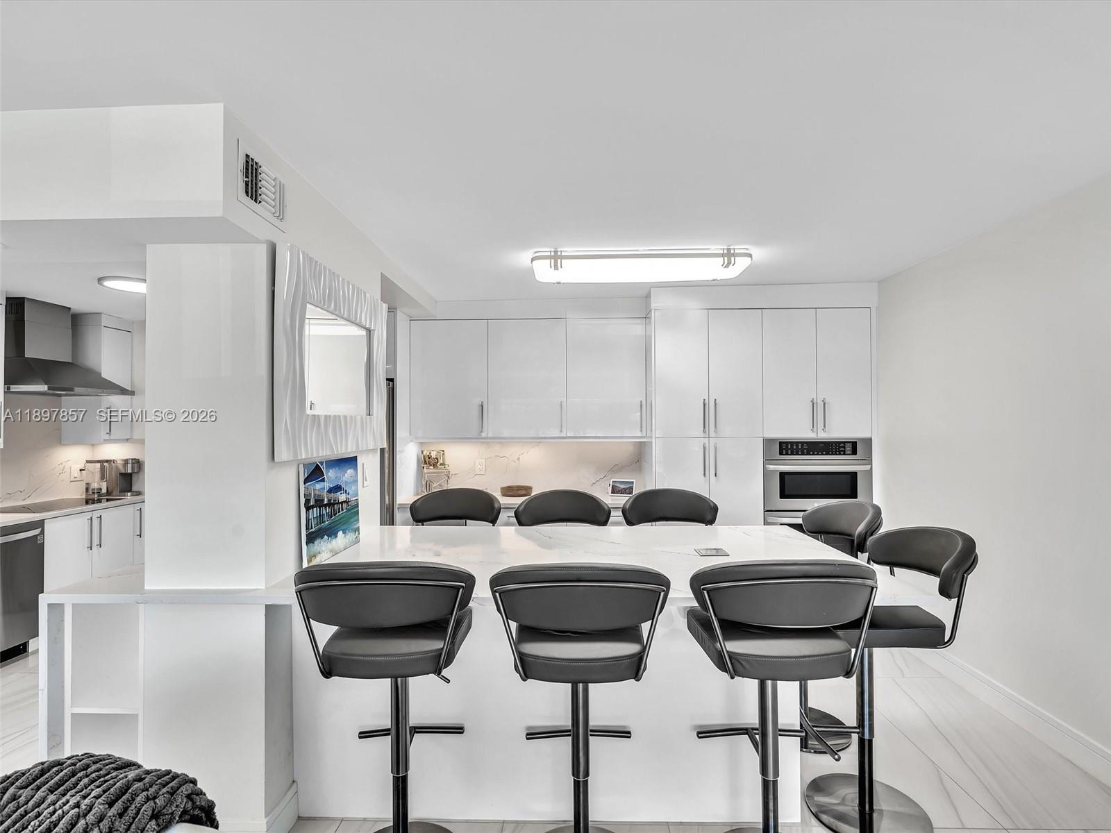 111 North Pompano Beach Boulevard, Unit 308 Pompano Beach, FL 33062 - Photo 11 of 50 a kitchen with a dining table chairs stainless steel appliances and cabinets
