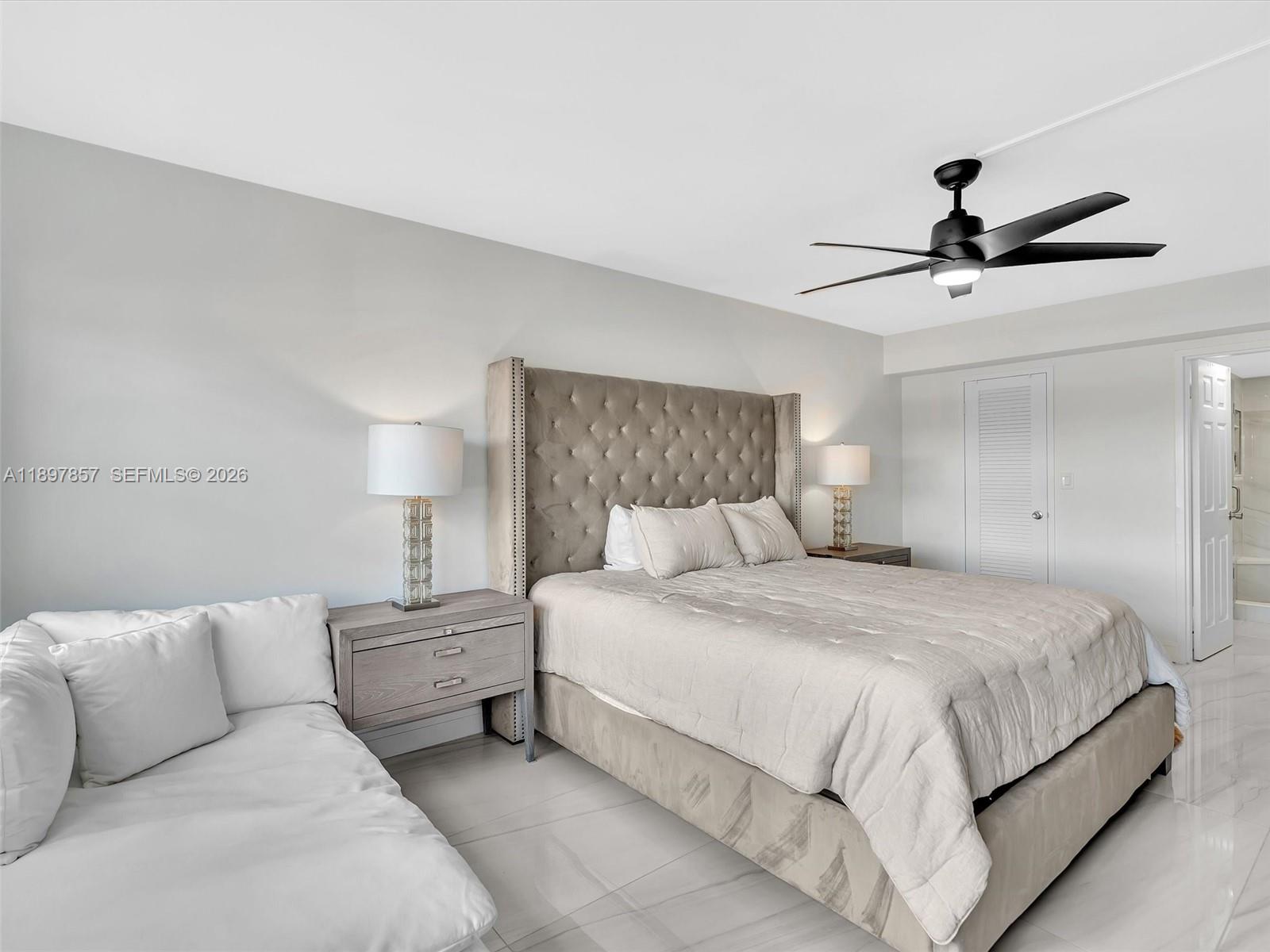 111 North Pompano Beach Boulevard, Unit 308 Pompano Beach, FL 33062 - Photo 14 of 50 a bedroom with a bed and a ceiling fan